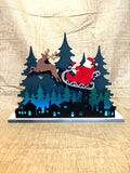Santa over the city lighted shelf sitter